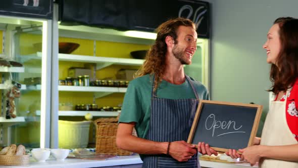 Portrait of workers holding a open sign