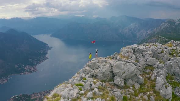 Couple Travelers Stand on the Peak Mountain Overlooking the of the Kotor Bay Montenegro