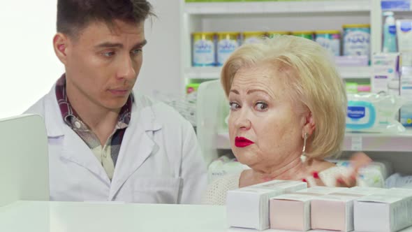 Senior Woman Asking Pharmacist for Advice, Shopping at Drugstore