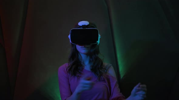 Young Pretty Girl Uses Virtual Reality Glasses.