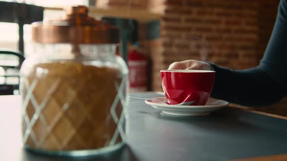 Red Cup of Steaming Hot Coffee on Table in Cafe