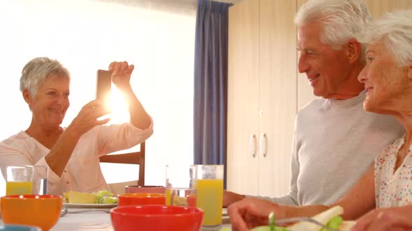 Senior couple being photographed by a friend