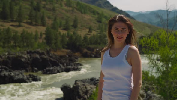 Woman in Sleeveless Shirt on Rocky Bank of Fast Creek