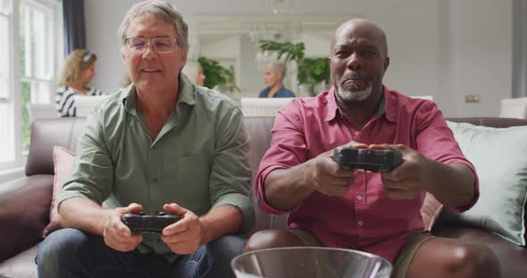 Animation of happy diverse male senior friends playing video games