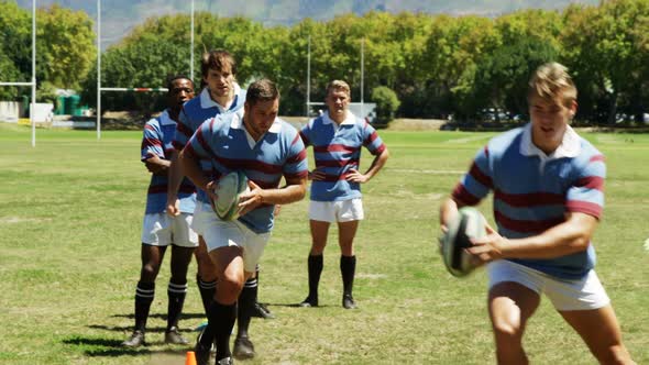 Players practicing rugby in the field 