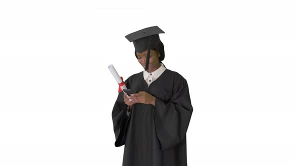 Happy African American Female Graduate Holding Diploma and Texting on Her Phone on White Background