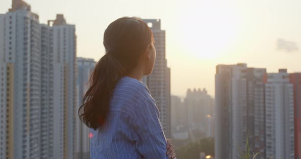 Woman look at the city building in Hong Kong in the evening time