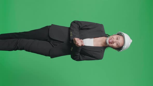 Smiling Asian Female Engineer Talking While Walking In The Green Screen Studio