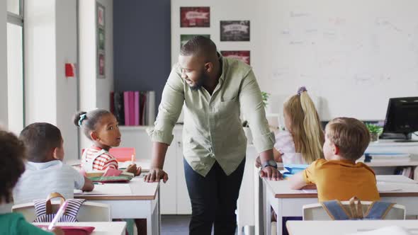 Video of happy african american male teacher during lesson with class of diverse pupils alt