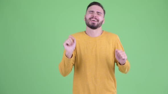 Happy Young Handsome Bearded Man Touching Something and Dancing