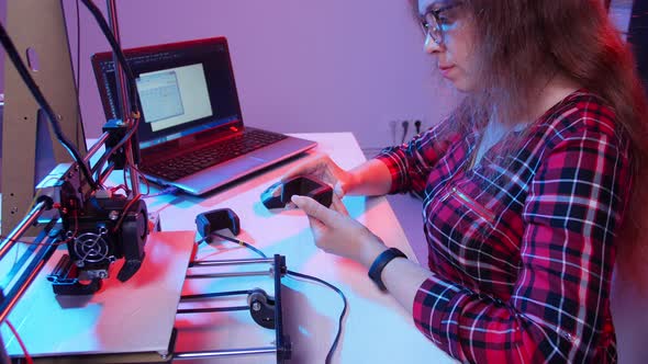 Concept of Modern Production Technologies. Young Woman Prints a Model on a 3D Printer