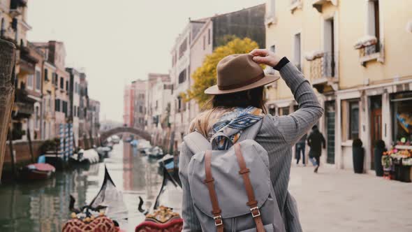 Happy Young Stylish European Woman Tourist in Hat Enjoying Looking Around Standing By Famous Venice