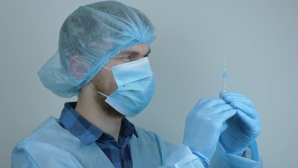 Virus protection and vaccination. Man in protective gear with syringe for injection