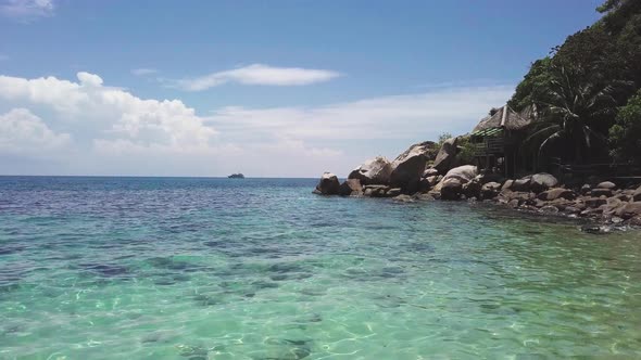 Coral Reef in Turquoise Lagoon Water Beside Rocky Shoreline with Big Stones in Tropical Country