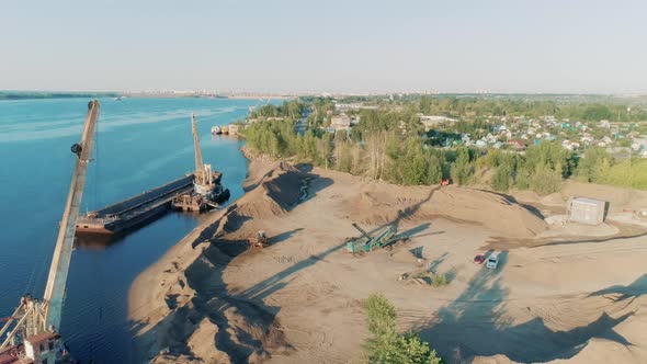 Construction Cranes and Trucks on Shore