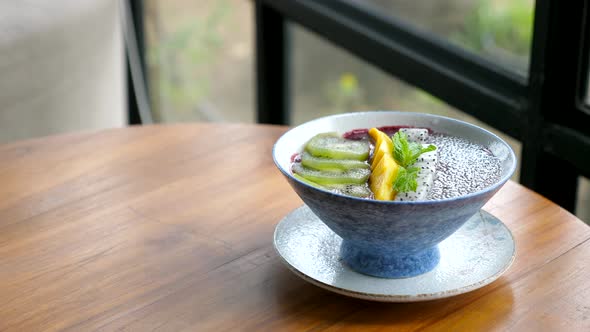 Smoothie Bowl with Tropical Fruits and Chia Seeds in Cafe