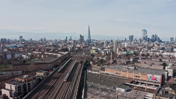 aerial drone shot of trains entering central London bridge station shard