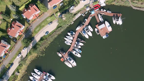 Drone flyover top shot aerial bird view of tiny boats, ships and private yachts in the new harbour o