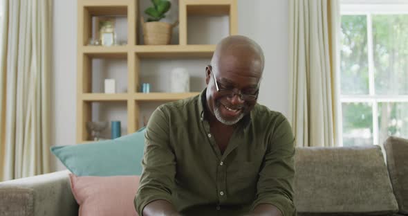 Portrait of smiling senior african american man making video call in living room