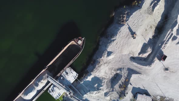 Aerial top down view of loading dry cargo ship.