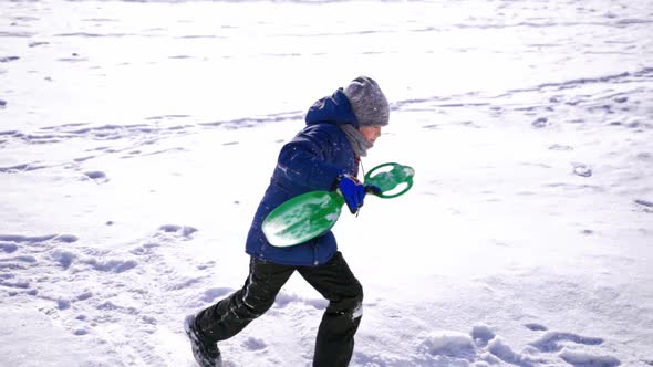 Child boy having fun, playing on a snowy winter walk in nature. Frost winter season.