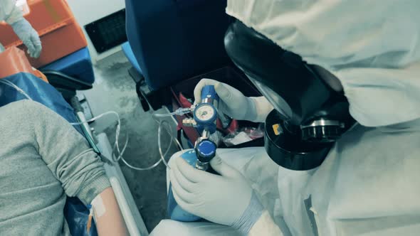 Doctor Is Regulating an Oxygen Tank Connected To a Patient