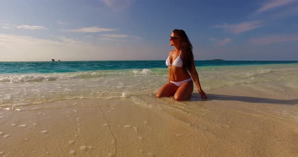 Sexy beauty model relaxing by the sea on the beach on paradise white sand and blue background 