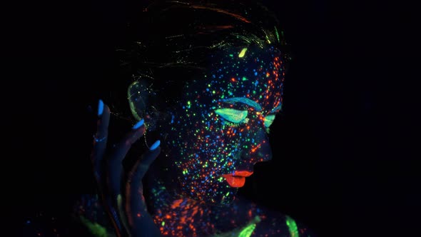 Fashion Model Woman in Neon Lights Posing in Studio, Portrait of Beautiful Girl,. Face Painted with