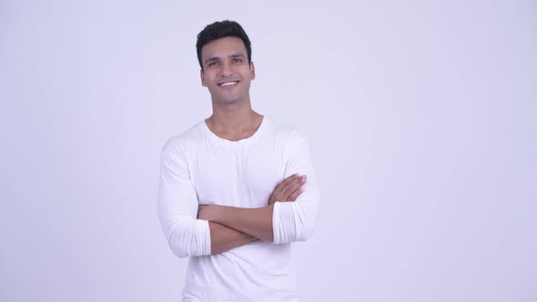 Happy Young Handsome Indian Man Smiling with Arms Crossed