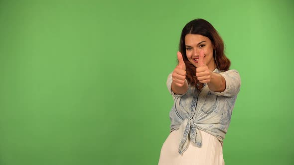 A Young Beautiful Caucasian Woman Shows a Double Thumb Up to the Camera with a Smile  Green Screen