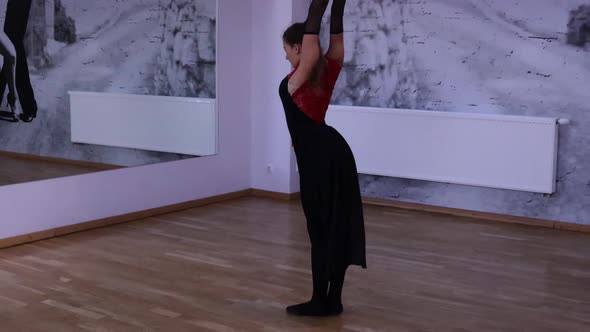 Professional female dancer dances on the dance floor in front of the mirror