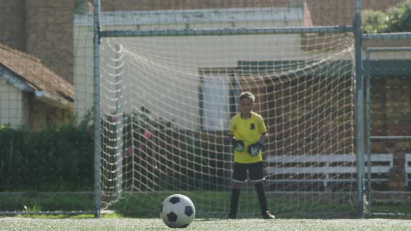 African American soccer kid in red scoring in a sunny day