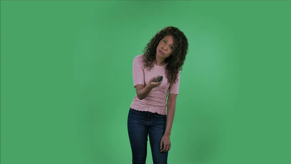 Portrait of Beautiful African American Young Woman with TV Remote in Her Hand, Switching on TV