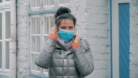 Woman in City Street Putting on Face Protective Mask, Virus COVID-19