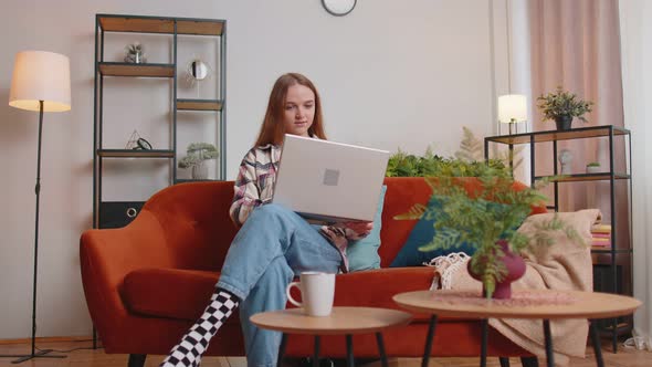 Caucasian Young Woman Sitting on Sofa Opening Laptop Pc Starting Work Online in Living Room at Home