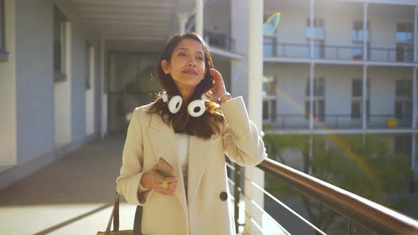 Slow motion shot of Indian woman with smartphone and headphones