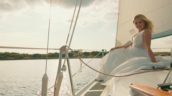 Bride on a Yacht at Sunset. The Bride's Gaze in the Distance, the Sun's Rays