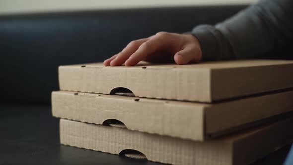 Closeup of Unrecognizable Delivery Man Tapping on Cardboard Pizza Box While Waiting for Customer