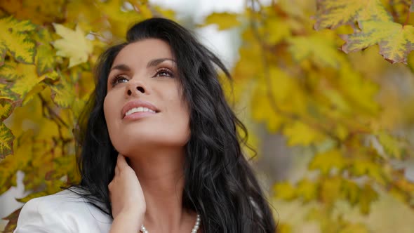 Stunning Brunette Woman in Park in Autumn Day Closeup Portrait in Background of Yellowed Maple
