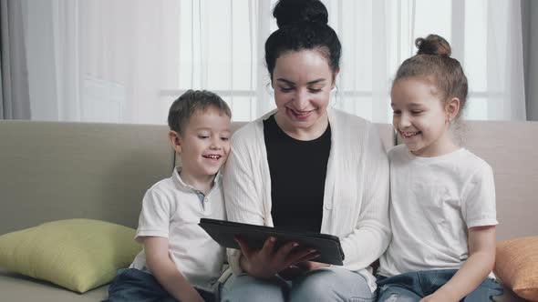 Happy Mom and Cute Daughter Little Kidmother Playing with Child at Home Relaxing Use a Smartphone