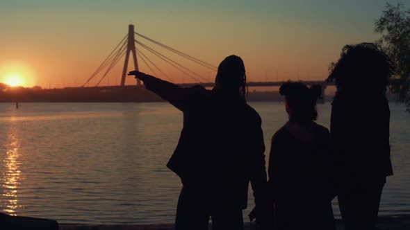 Relaxed Family Silhouette Standing on River Shore