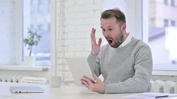 Upset Creative Man Reacting To Failure on Tablet