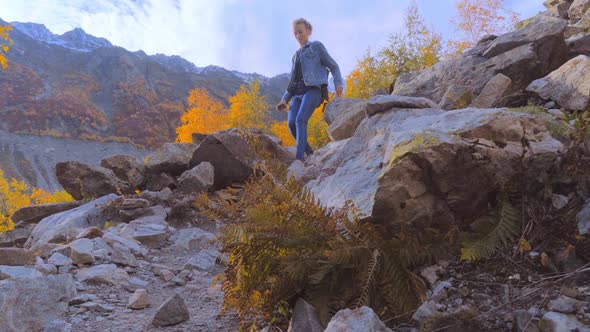 A young beautiful slender woman alone in the mountains.