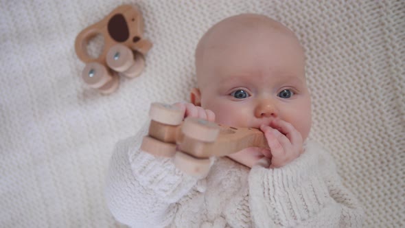 Cute Baby Girl Playing With Wooden Eco Toy Wearing Knit Sweater. 