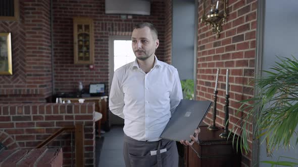 Portrait of Confident Male Waiter with Mustache Walking with Menu in Slow Motion Leaving