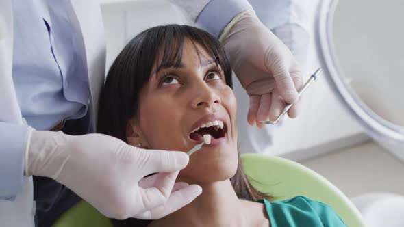 Male dentist examining teeth of female patient at modern dental clinic