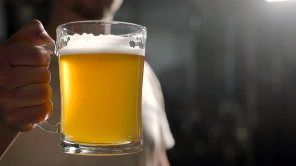Close-up Shot of a Brewer Raising a Glass of a Freshly Made Light Beer