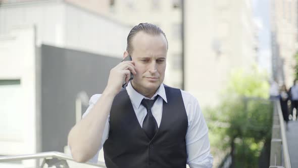 Businessman talking on cell phone outdoors