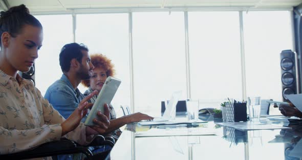 Executives working on electronic gadgets in office