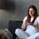 Young Beautiful Caucasian Woman Woman Using Mobile Phone Surfs Internet Indoors at Home Living Room - VideoHive Item for Sale